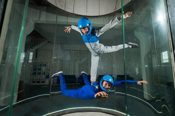 Fototapeta premium A man and a woman enjoy flying together in a wind tunnel. Free fall simulator