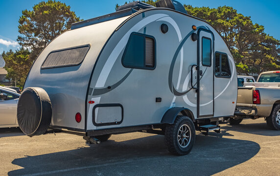 Small caravan pulled by the car. Traveling on vacation. Tiny house on wheels. Adventurous outdoor living concept.