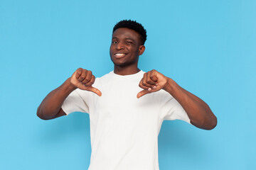 displeased african american man in white t-shirt showing dislike on blue isolated background, guy...