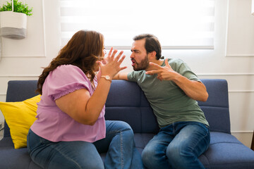 Fototapeta na wymiar Couple looking angry fighiting and screaming with problems