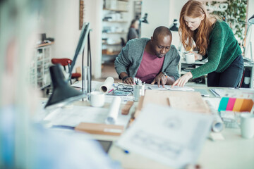 Young man and woman working together on a project in a startup company office