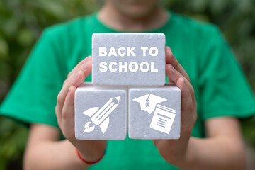 Little schoolgirl holding white plastic foam blocks with inscription: BACK TO SCHOOL. Educational...