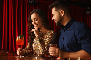 Lovely couple with fresh cocktails at bar counter