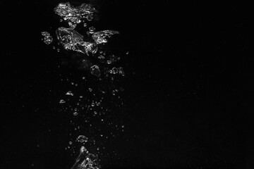 Air bubbles in water on black background, space for text