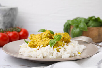 Delicious rice and chicken with curry sauce on white textured table, closeup