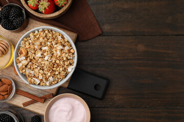 Tasty granola, yogurt and fresh berries served on wooden table, flat lay with space for text. Healthy breakfast