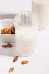 Fototapeta na wymiar Almond milk in ribbed glass close-up, dairy alternative