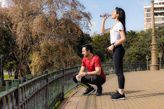 Woman and man resting drink water after exercise.