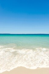 Clear turquoise waters, cloudless blue skies, and sea foam on a sunny day at Callala Beach in Shoalhaven — Jervis Bay National Park, New South Wales, Australia