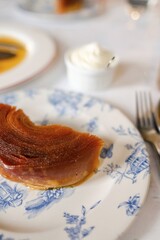 A French apple tart (Tarte tatin) with mascarpone served on classic crockery at a bistro in...