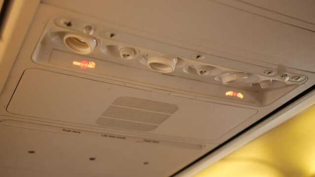 Seat belt sign light turning on in the cabin of an airplane passenger airliner plane