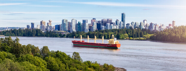 Fototapeta na wymiar Cargo Ship arriving to the Port of Vancouver. Downtown City in background. Vancouver, BC, Canada