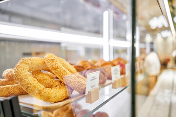 The bun Simit in the foreground. Lot of croissant is fresh and hot in a cafe next to other types of pastries. A variety of fresh pastries in the bakery window. The interior of an Italian restaurant.