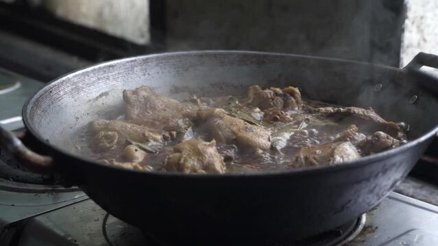 Medium shot of Chicken Adobo being cooked. Adobo is a popular Filipino cuisine. The shot was taken from a kitchen near a window with beautiful natural light.