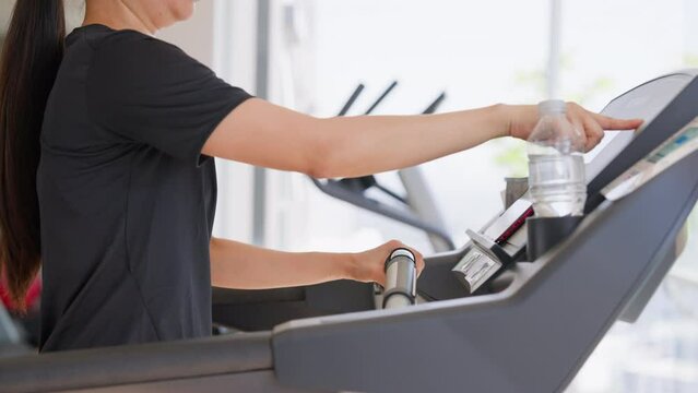 Fitness female walking on treadmill. Asian woman workout cardio and training at gym