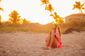 Cute teen beautiful girl on tropical seashore at sunset