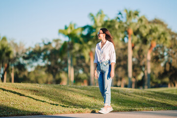 Happy young woman walking outdoor in the park  - 634914563