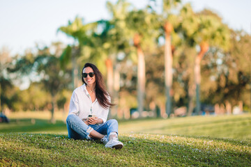 Portrait of happy young woman outdoor in the park at sunset - 634914942