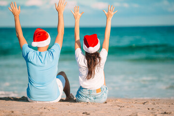 Christmas happy couple in Santa hats on beach vacation - 634915998