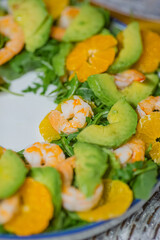 Green healthy vegan salad with arugula, avocado, shrimps and tangerines - 634916154