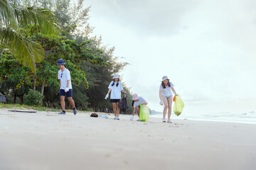 Volunteers of boys and girls happily picking up trash on the beach.