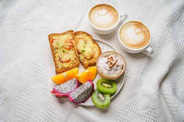 Breakfast toast with cheese and tomatoes, fruit, yogurt, coffee.