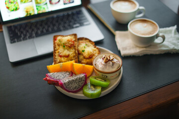Breakfast toast with cheese and tomatoes, fruit, yogurt, coffee.