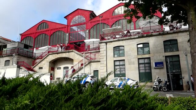 Tourist walks in front of Ferreira Borges Market and Police Station, Porto