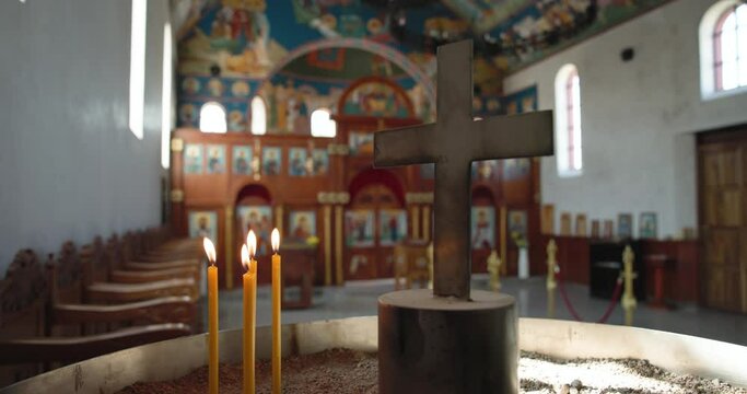 Botswana, Gaborone, orthodox serbian church ,candles burning and a cross, worship prayer pew wooden chairs in a row along the church wall