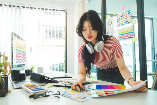 Portrait of pretty asian female interior designer in stylish clothes standing at creative office.