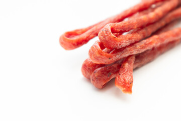 Pork or beef sausage, dry sausages, meat stick smoked close-up. Polish thin, long, dry sausage on a white background