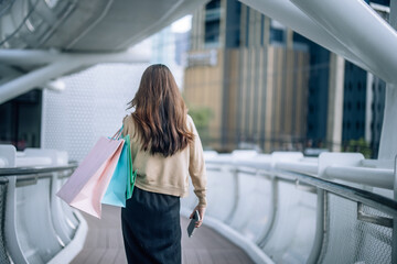 Stylish lady strolls downtown, explores new stores, and smiles while enjoying chic weekend shopping