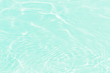 Blue water with ripples on the surface. Defocus blurred transparent blue colored clear calm water surface texture with splashes and bubbles. Water waves with shining pattern texture background.