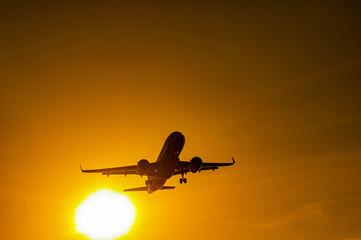 Fototapeta na wymiar Bottom view of a flying plane at sunset. 