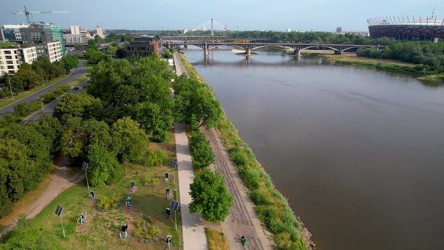 Park and walkway next to Vistula river with Poniatowski bridge, Warsaw, Poland