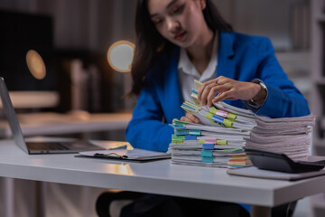 Portrait of Asian Stressed business woman sitting and working hard at with front of computer and...