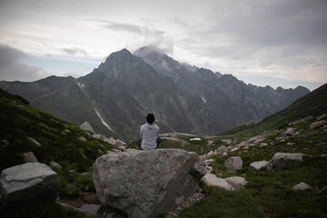 岩の上に座って剱岳を眺める男