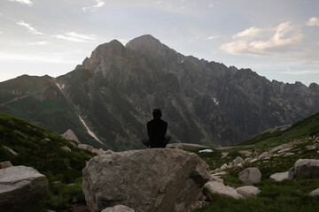岩の上に座って剱岳を眺める男