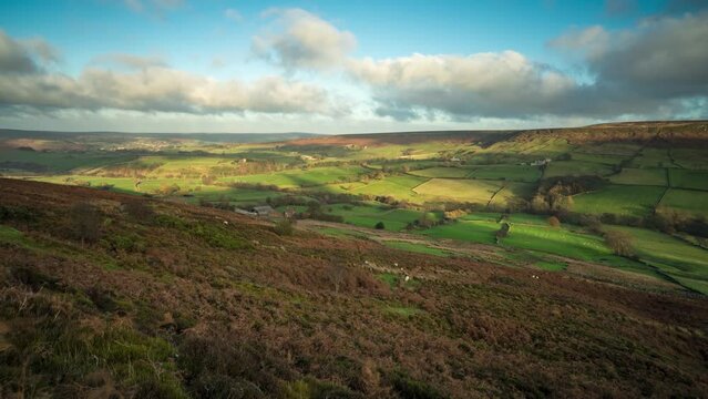 A timelapse of Danby Dale in the North York Moors National Park in autumn with sunlight streaming over the valley and pan across.