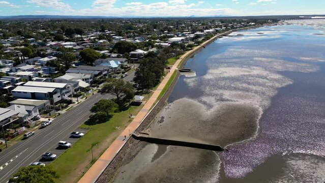 Aerial view, reversing, of the Sandgate and Brighton waterfront on a sunny day, Brisbane, Queensland, Australia