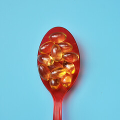 Pills in a red spoon on a blue background
