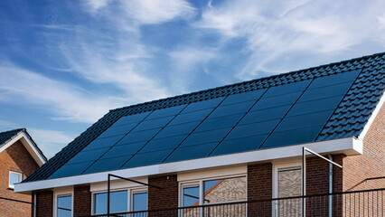 Newly build houses with solar panels attached on the roof, Photovoltaic panels on the roof. Roof Of...