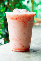 Strawberry smoothies with milk in the garden