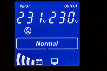 Closeup of blue digital display on uninterruptible power supply with automatic voltage stabilizer
