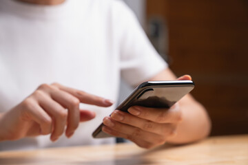 Woman holding black smartphone and chatting online message on mobile.