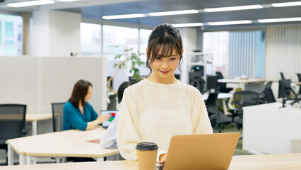 オフィスで仕事するカジュアルな女性