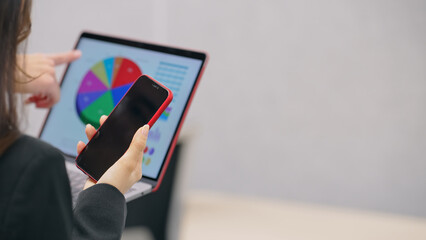 スマホとノートパソコンを持って会話するビジネスパーソンのグループ