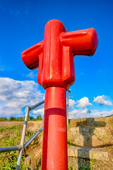 View of Styled Red Fire Cock Hydrant Against of Blue Sky On The Street Of City.