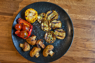 Cuisine Concepts. Delicious and Mouthwatering Vegan Grilled and Roasted Set of Fresh Vegetables Placed on Black Plate