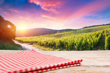 empty wooden table on the background of vines, tuscan landscape at sunrise. High quality photo